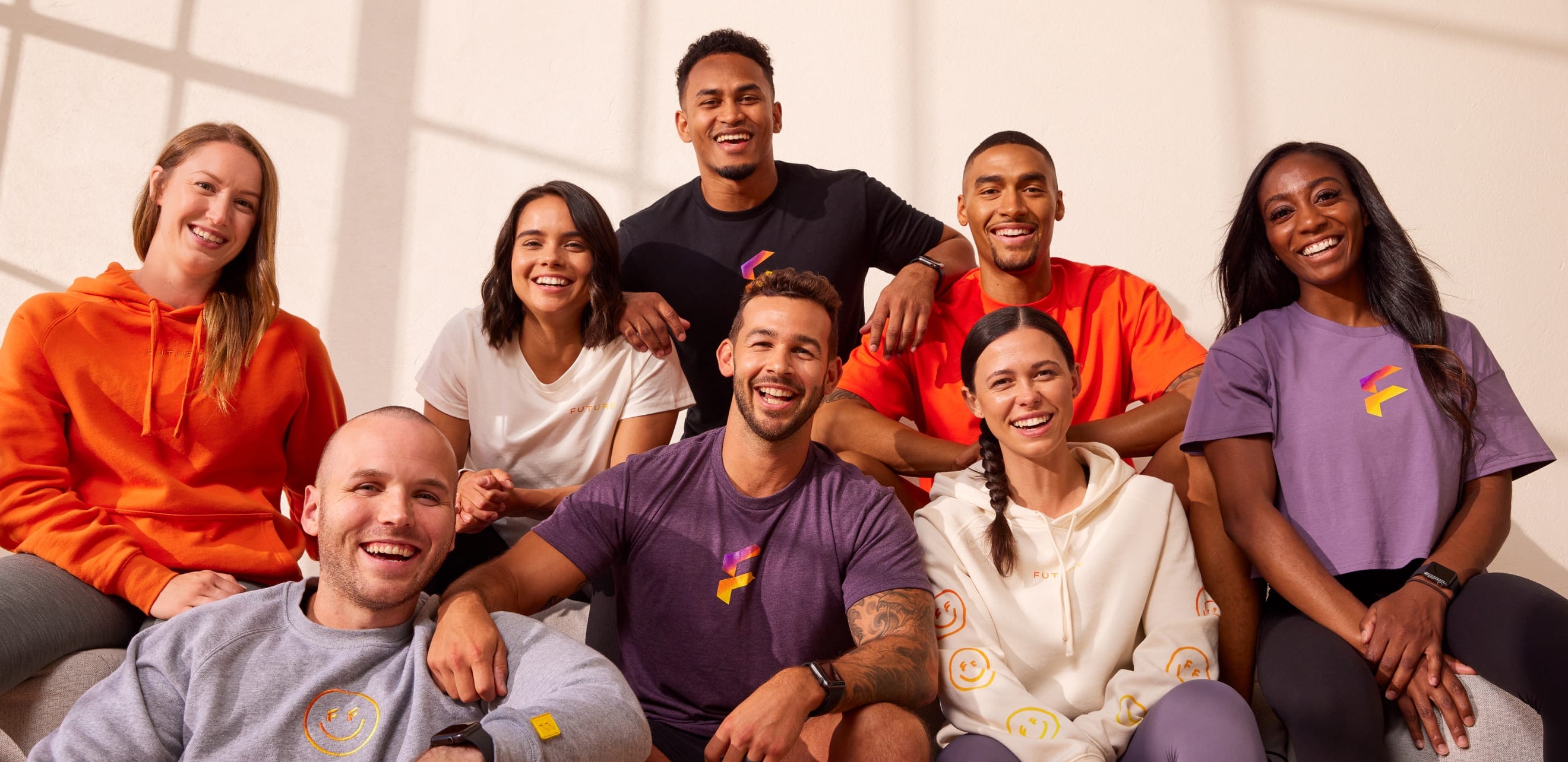 A diverse group of eight Future coaches pose together in casual athletic wear